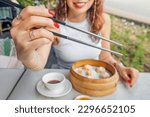 Small photo of Girl showing how to hold chinese chopsticks. Rules of etiquette and oriental cuisine