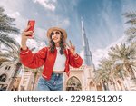 happy tourist asian girl taking selfie photos for her travel blog, in Dubai downtown