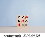 Small photo of Business goal strategy planning and marketing with tic tac game and dart icons on wooden cubes. Company strategy to achieve target to be successful. Find the best direct with O and X game to target.