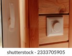 Small photo of Close up electrical dimmer switch light for adjustable brightness control in wooden house. Saving energy concept.