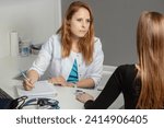 A doctor consulting oxygen saturation and heart rate with a pulse oximeter.Mature female professional doctor with stethoscope on shoulders measuring oxygen saturation of young woman.