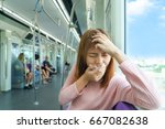 Small photo of Portrait of young woman headache or carsick while taking the sky train
