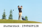 Small photo of Golfer asian man approach on tee off for swing and hitting golf ball on slope green and looking fairway in course. Hobby playing game golf in holiday and vacations day on club golf. Lifestyle sport