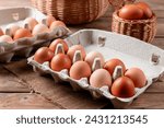 Small photo of Happy Easter. Easter eggs. Chicken brown eggs close-up on the wooden table. A carton crate of fresh brown eggs. Organic chicken eggs in a egg carton.