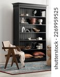 Small photo of Eclectic style room with rattan, coastal style chair and elegant, black bookcase with different styles decorations