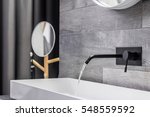 Modern white washbasin with black tap mounted to wall