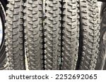 A variety of bicycle accessories are on display in a bike shop. The focus is on different types of tires with deep tread patterns. Perfect for off-road adventures