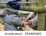 Young Child Feeding Straw To...