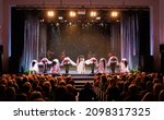 Small photo of A collective of musicians, singers and dancers in gypsy costumes perform on stage.