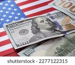 Small photo of American money. 100 dollars on the American flag. World economic crisis. Currency exchange. Fed