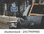 Small photo of Older model truck with plow front driving past the Vail sign on route I-70 east heading towards Denver and the foothills of Colorado, USA 2024. Frisco, Keystone, Dillon, many mountain towns on route