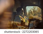 Mid adult driver behind steering wheel of a truck. The view is through the glass.