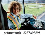 Small photo of Happy female driver in public bus looking at camera.