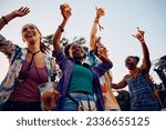 Small photo of Happy African American woman and her friends attending open air summer music festival.