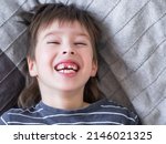 Small photo of Laughing kid shows hole in row of teeth in his mouth. One incisor fell out just now. Close up photo of gums for dentist.
