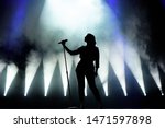 Vocalist singing to microphone. Singer in silhouette.
