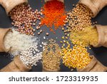 Different type of raw dry legumes composition. White beans, lentils, bulgur, chickpeas, kidney beans, corns, rice, in burlap sack Mix organic legume concept