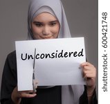 Small photo of A pretty girl cut the word unconsidered . Transformation from negative to positive or bad to good concept.