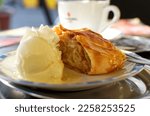 Apple strudel with vanilla ice cream and a cup of coffee