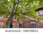 Small photo of YSTAD,SWEDEN - AUGUST 12: Tree with pennants and a banner with the typo Cafe in front of a historic building and the restaurant Helsa pa AB on August 12,2015 in Ystad.