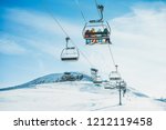 People on ski lift in winter ski resort - Holidays, snow gear renting, skiing, snowboarding and mountain landscape concept - Focus on guys sitting in cable car