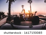Happy people having fun in convertible car in summer vacation at sunset - Young couple enjoyng  holiday on cabriolet auto outdoor - Travel, youth lifestyle and wanderlust concept - Focus on hands