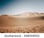 Competitors in the Marathon des Sables traverse a sahara desert dune