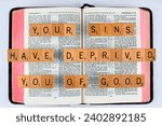 Small photo of Vancouver, BC, Canada - Circa Dec. 2023: Scrabble letters spelling Bible Verse Jeremiah 5:25 Your sins have deprived you of God