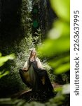 Small photo of Beautiful seductive dryad. Pagan spirit of forest. Portrait of beautiful dryad. Fairy who loves nature in beautiful green summer forest. Concept of environmental friendliness and caring for nature