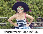 happy pretty woman smiling in the beach wearing a Black and white striped dress with the sea and green in the background