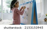 Small photo of Little cute girl happy play and learn offline class computer language on board game Unplugged Coding computing concept for asia people kindergarten gen Z smart kids at home. STEM STEAM ICT skill.
