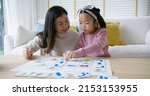 Small photo of Little cute girl play and learn offline class computer language game Unplugged Coding computing concept with mom for asia kindergarten gen Z smart kids sit at table home sofa. STEM STEAM ICT skill.