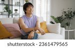 Small photo of Gay queer asian man non-binary influencer sitting easy at home sofa. Asia non binary LGBT young guy adult two people happy relax smile talking asking advice face to face in mental health care therapy.