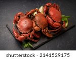 Small photo of Steamed Red Crab with butter and lemon, Boiled Serrated mud crab on black plate on black background