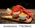 Cooked Organic Alaskan King Crab Legs with Butter and lemons, Alaskan King Crab on vintage wooden background.