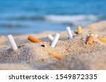 Cigarette Butts In Yellow Sand...