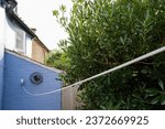 Small photo of Shallow focus of a rear garden wall showing an extended washing line extending out of view and fixed to a garden fence post.