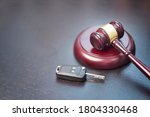 Small photo of Driver license revocation concept next to the judge hammer. Traffic violation concept by car next to judge hammer. Revocable trust on a dark desk.