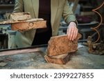 Small photo of The intricate textures and rich tones of burl wood are about to be shaped into art, as seen through the discerning eyes of an experienced craftsperson.