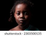 Small photo of A striking studio portrait of a 6-year-old African-American girl of Ethiopian descent, captivating the viewer with her warm smile.