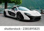 Small photo of Como, Italy - October 28, 2023: A white McLaren P1 parked on a windowsill in front of Lake Como. What a beautiful show! For the car or for the lake?