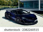 Small photo of Como, Italy - October 28, 2023: Pearly navy blue McLaren P1 LM worth 3 and a half million euros parked on the driveway of a business.