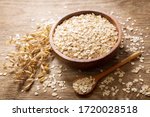 oatmeal flakes and ears of oat on wooden table
