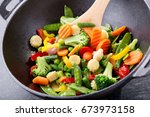 stir fried vegetables in a wok on dark table