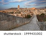 Gravina in Puglia, Bari, Italy: landscape at sunrise from the ancient aqueduct bridge of the old rock church and the cave houses carved into the tuff rock 