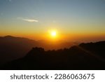 Chasing a magical sunrise at the top of Mount Kelimutu which is located in Ende regency, Flores island, Indonesia, with the golden rays of the sun and the beautiful silhouettes of the mountains