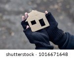 young homeless boy holding a cardboard house
