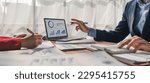 Small photo of Two business people talk project strategy at office meeting room. Businessman discuss project planning with colleague at modern workplace while having conversation and advice on financial data report