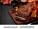 Grilled beef steak on the dark wooden background.