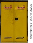 Small photo of a cupboard made of yellow iron specifically for the storage of hazardous materials. This includes chemicals and flammable materials